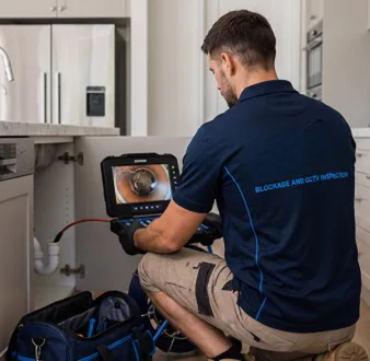 Plumber clearing a blocked toilet in a Eastwood bathroom